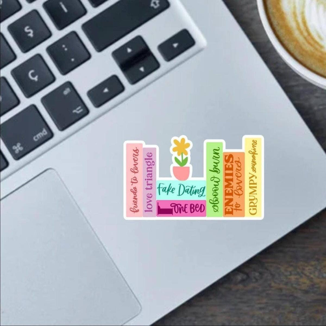 Set of colorful stickers on a laptop keyboard with a cup of coffee in the background