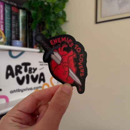 Hand holding a sticker with &