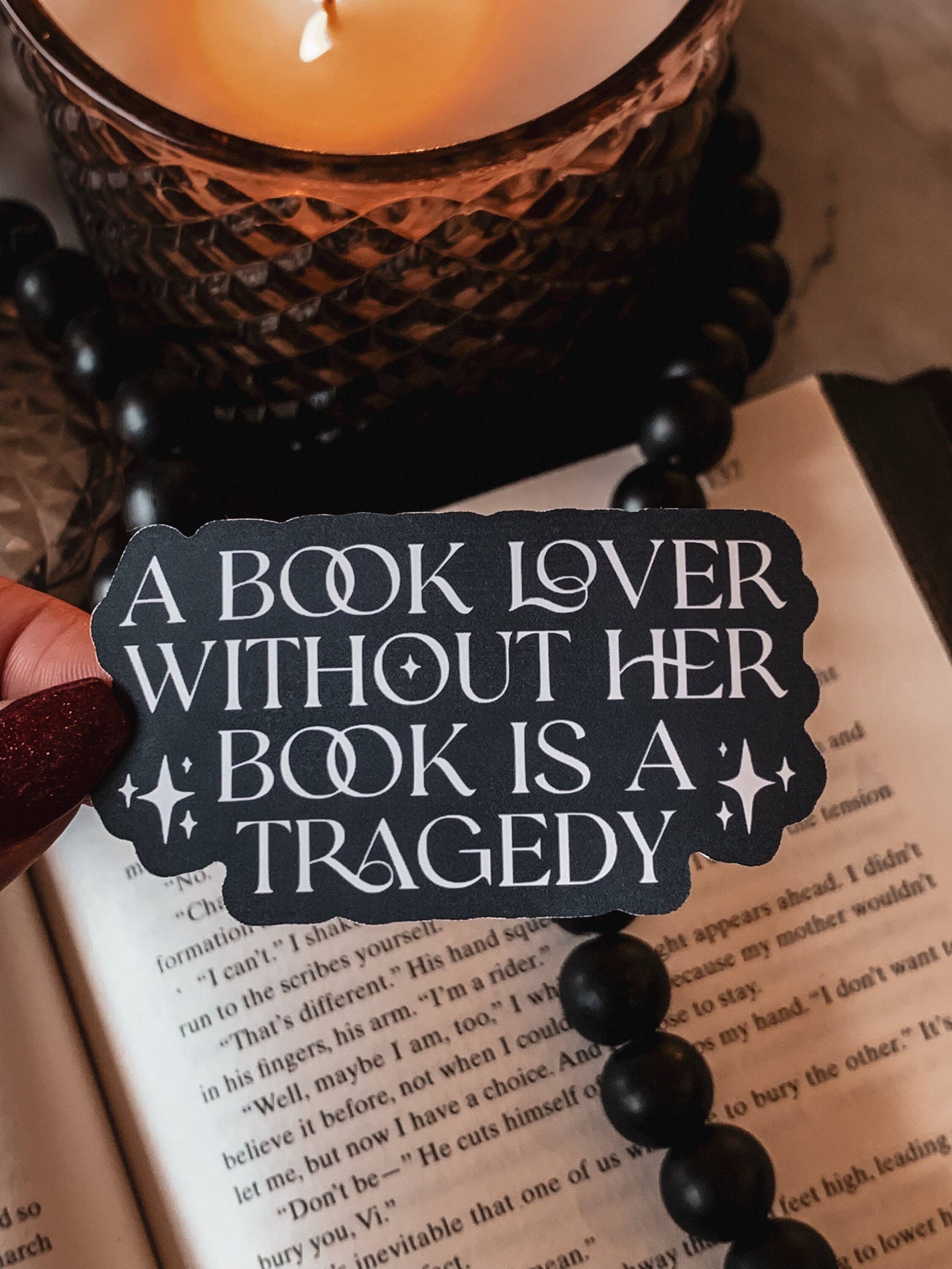 Book with a decorative candle and a quote tag on an open book
