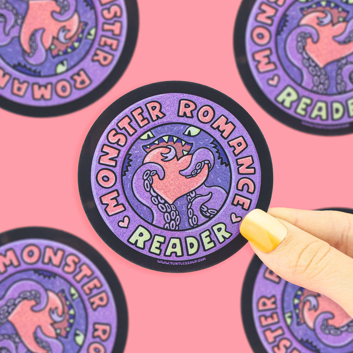 A circular sticker with a purple and pink monster illustration and the words &