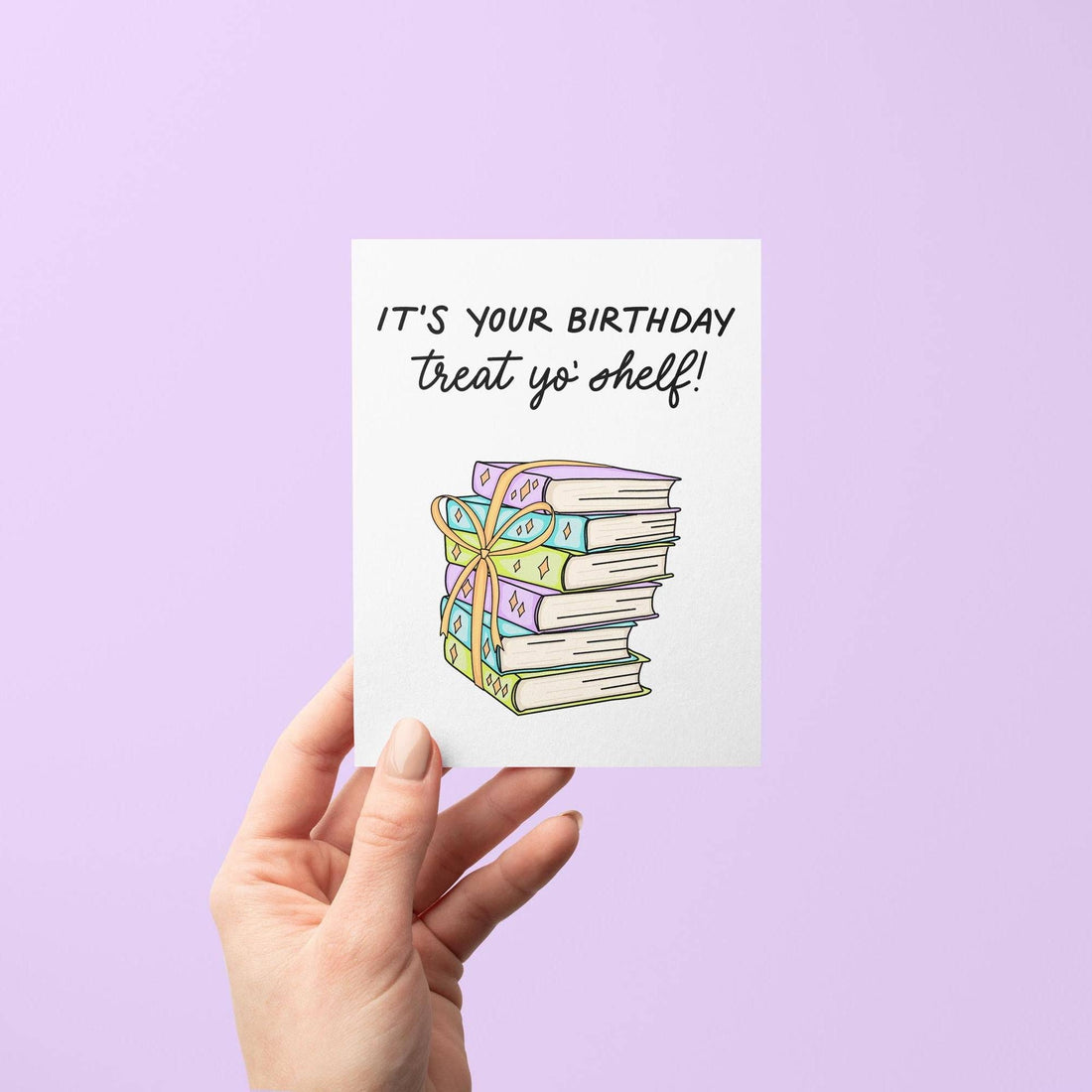 Hand holding a card with a stack of books and text on a purple background