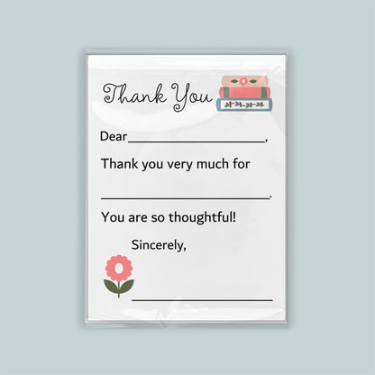 The image is a white thank you card with a pink flower and a stack of books as decorations. The card has a blank space for a message and a blank space for a signature.