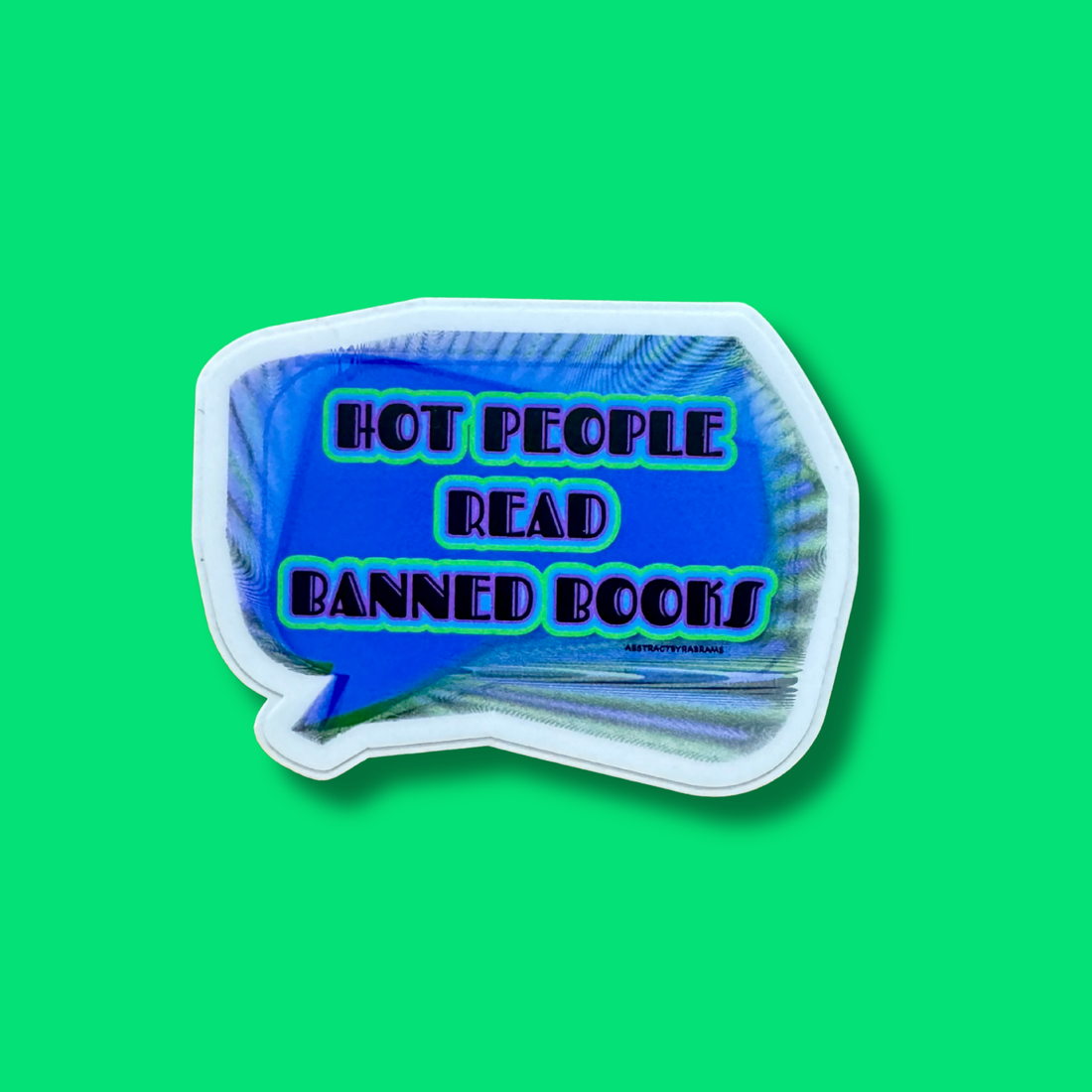 A die-cut sticker shaped like a speech bubble with the text &