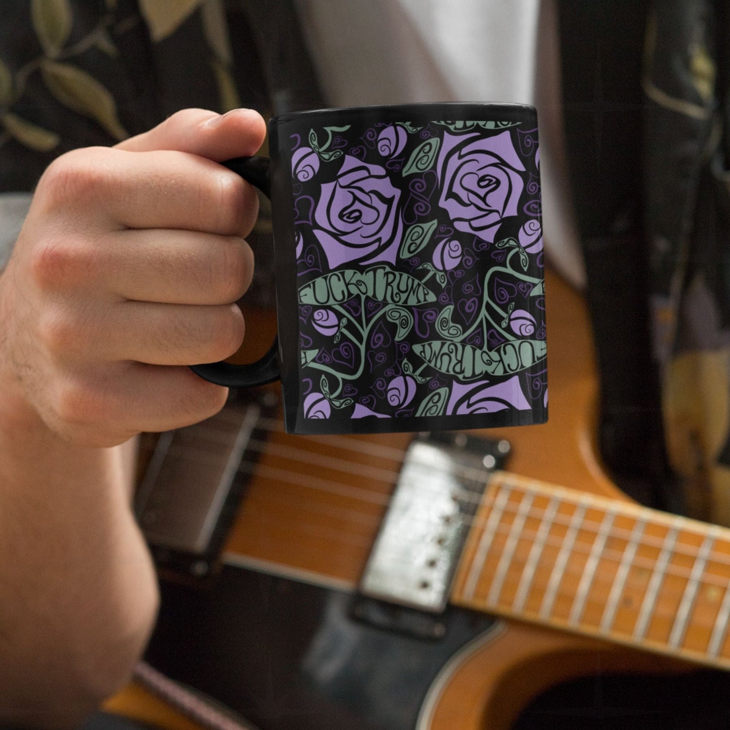 Person playing a guitar drinking from fuck trump floral gothic coffee mug