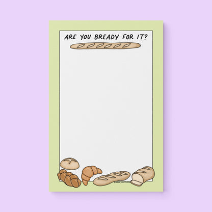 Notepad with green border, bread illustrations (baguette, croissant, loaf), and text “Are You Bready For It?” – cute Swiftie bread-themed stationery gift.