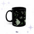 11 oz arsenic green cybergoth mug with a seated black cat, a skull, loose bones, and a rose on glossy black ceramic
