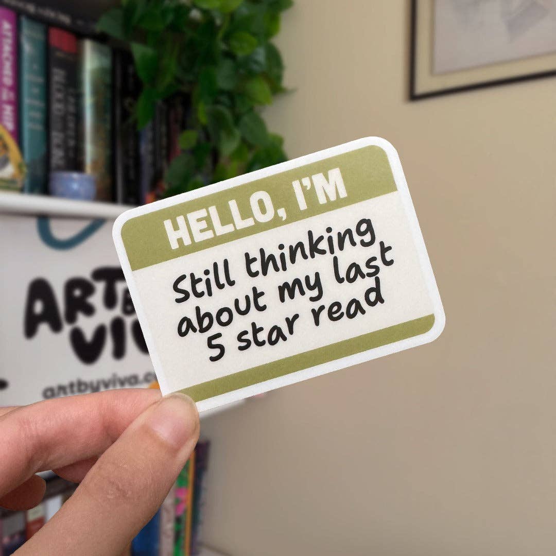 Hand holding a sticker with text &