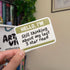 Hand holding a sticker with text &