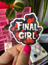 A hand with bright pink nail polish holds a die-cut sticker that reads &