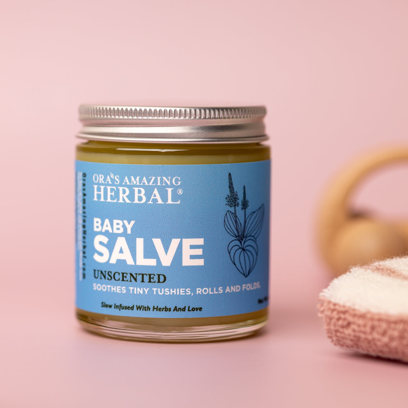 Baby Salve 4oz Lifestyle Indoor Pink Background Baby Props