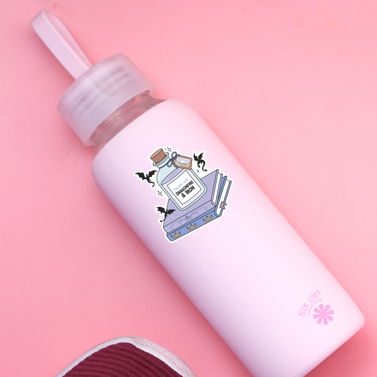 White bottle with a decorative label on a pink background
