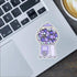 Laptop with a sticker of a gumball machine filled with books on a desk with a coffee cup.