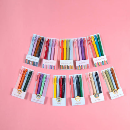 Set of colorful pens in their packaging on a pink background