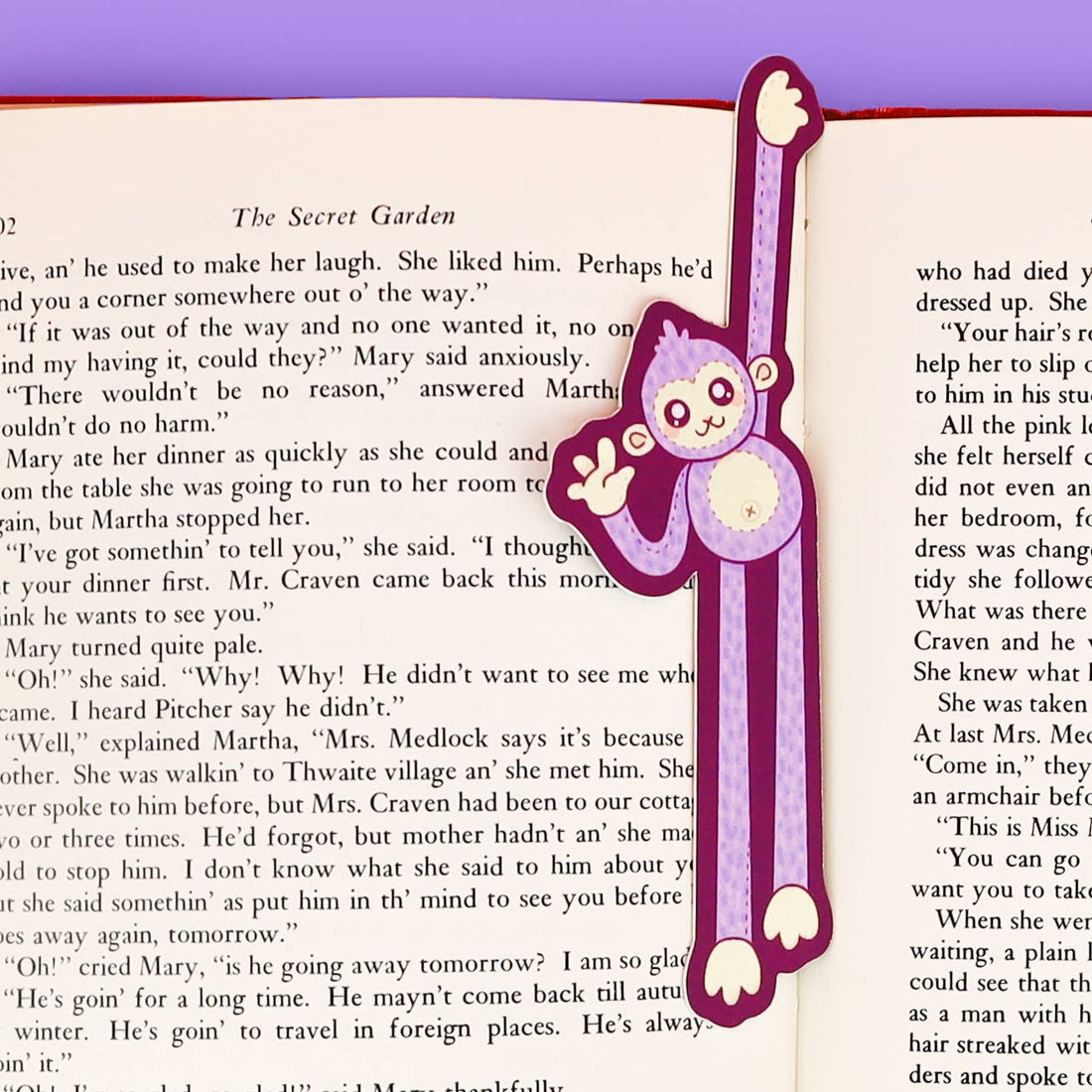 Bookmark with a purple monkey design on an open book