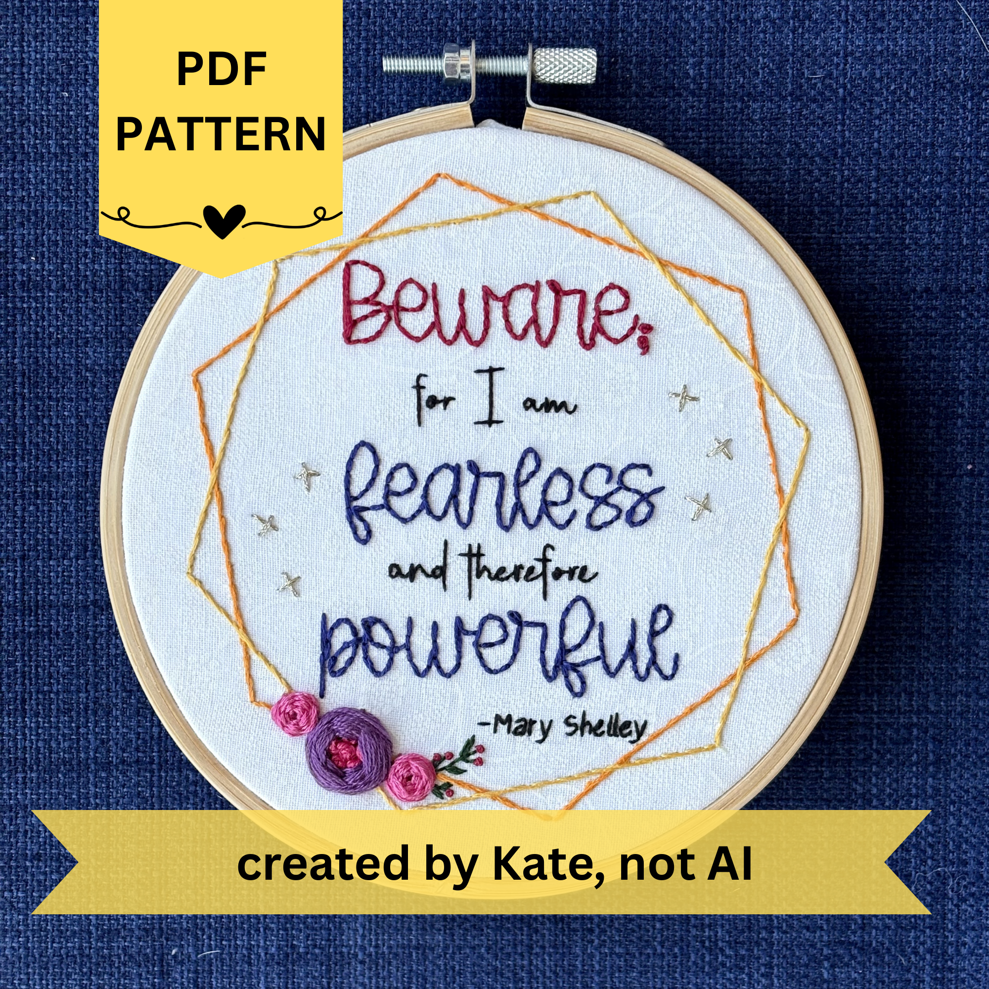 PDF pattern created by Kate, not AI. "Beware; for I am fearless and therefore powerful - Mary Shelley". Quote hand embroidered in dark red, black, and deep royal blue. Framed in yellow and orange hexagon wreaths with floral bundle on the bottom left. Gold stars sparkle on the sides. Fabric is white-on-white cotton. Displayed as wall art in a light wooden embroidery hoop.