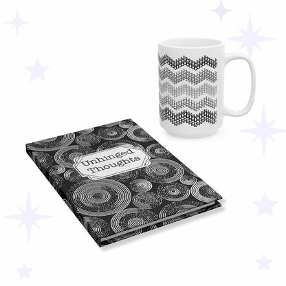 White ceramic mug with five gray chevron stripes beside a black hardcover journal covered in white concentric circles with an Unhinged Thoughts label plaque.
