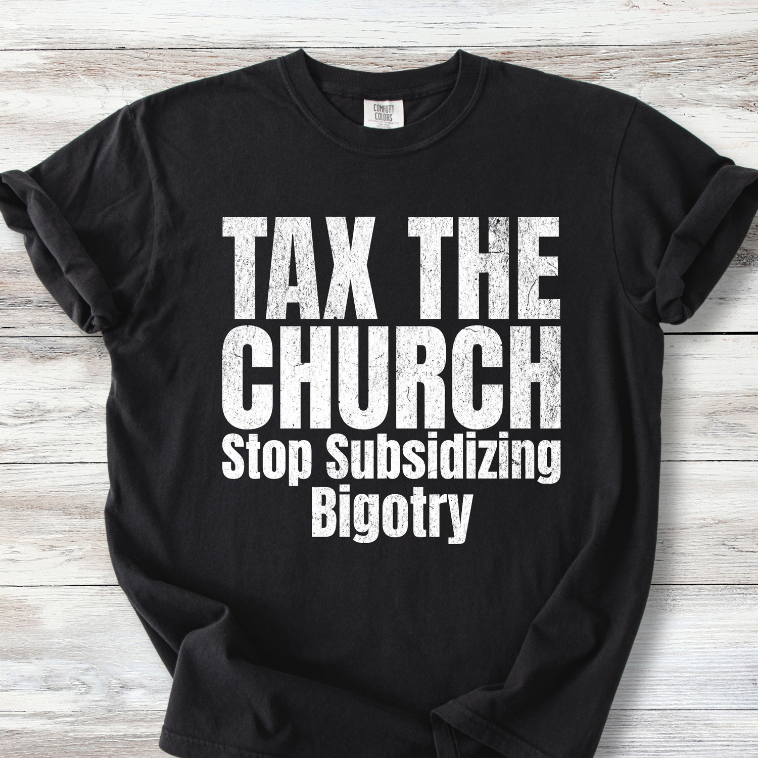  A Comfort Colors Tee with the words TAX THE CHURCH Stop Subsidizing Bigotry.  Available colors are black and denim with white lettering &amp; Ivory and Mustard with brown lettering. Lettering is bold with a bit of grunge.  