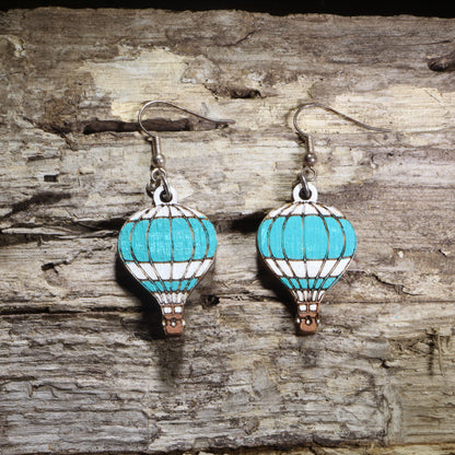 Handcrafted blue hot air balloon wooden dangle earrings featuring colorful hand-painted hot air balloons with engraved details. Lightweight laser-cut wooden earrings with hypoallergenic .925 sterling silver hooks, perfect for travel lovers, adventure seekers, aviation enthusiasts, wanderers, and unique handmade statement jewelry.