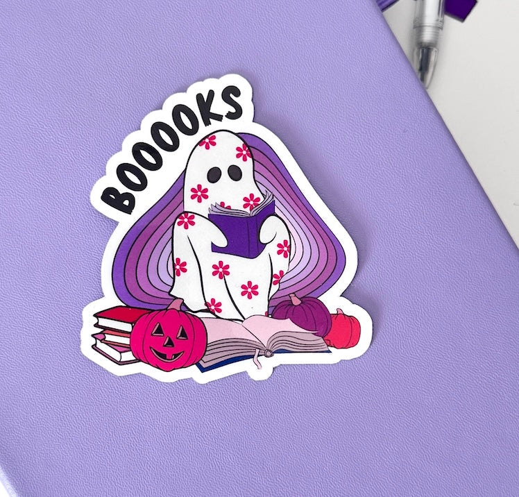 A die-cut sticker featuring a white ghost character with pink floral patterns reading &