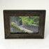 framed print of a stone bridge in a forest in the scottish highlands in a weathered style brown frame