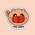 A die-cut sticker featuring a cute peach-colored cartoon cat holding a red book, with the text &