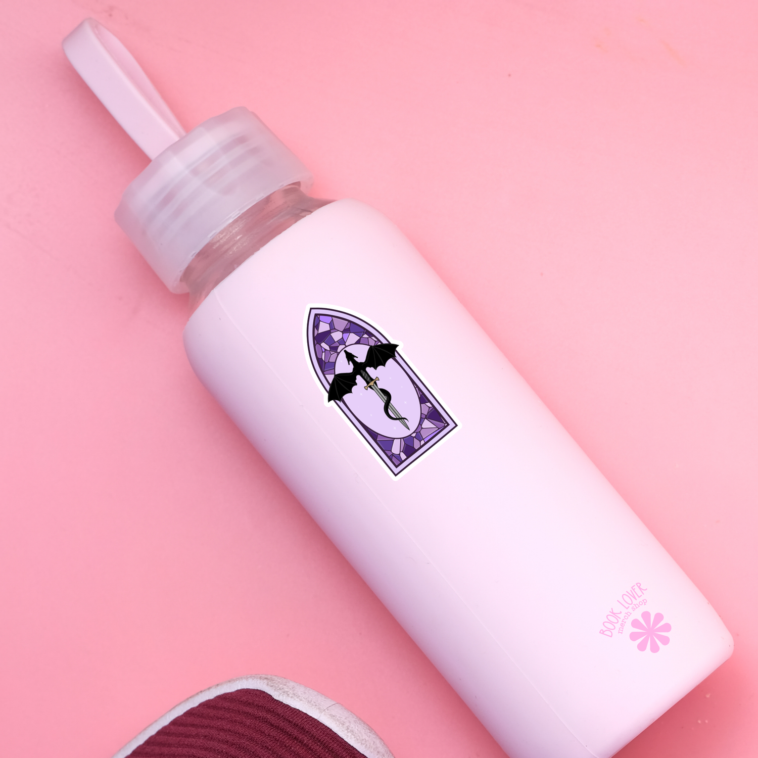 White bottle with a purple label on a pink background