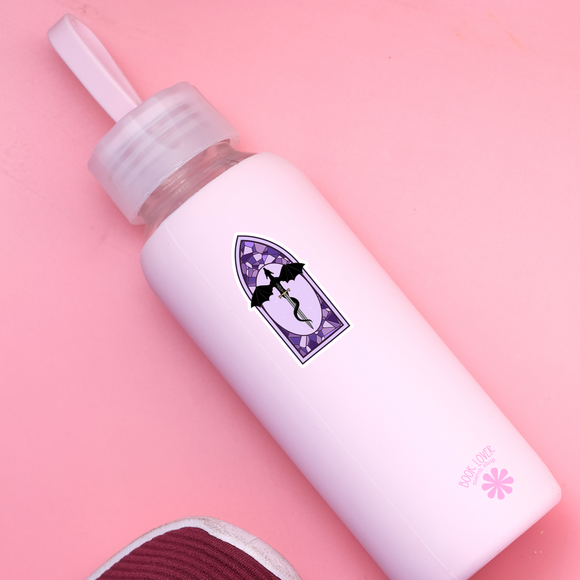 White bottle with a purple label on a pink background