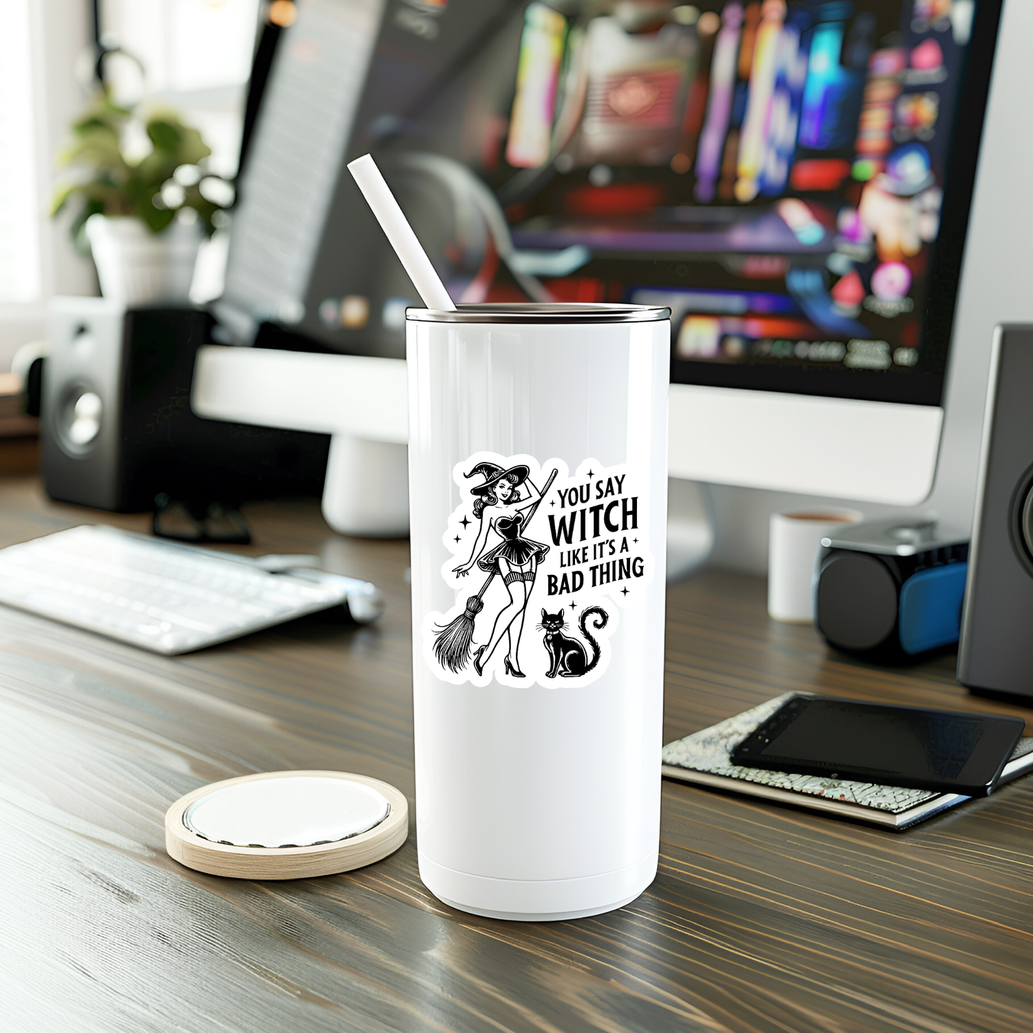 White tumbler with a graphic design on a desk with a computer in the background