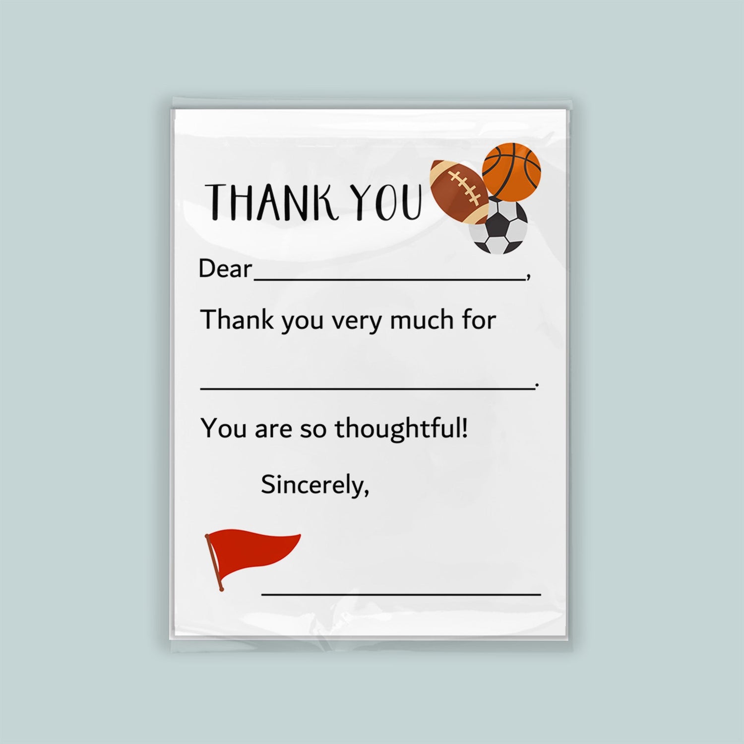 The image is a white thank you card with sports balls and a flag on the front. The card has a blank space for a message and a blank space for a signature.