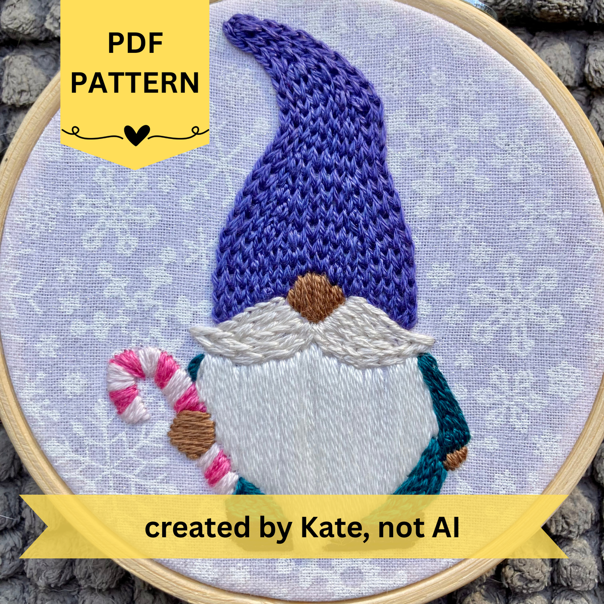 PDF pattern created by Kate, not AI. Hand embroidered Christmas gnome with a purple knit winter hat holding a candy cane. Stitched on white cotton with sparkly white snowflakes printed on the fabric. Displayed in light wooden hoop as a DIY handmade Christmas ornament.