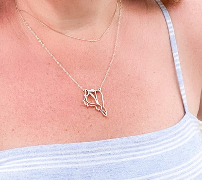 wearing gold captiva shell pendant necklace with light blue and white stripes