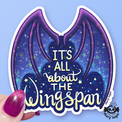 A die-cut vinyl sticker featuring purple bat wings on a starry blue night-sky background with the text &
