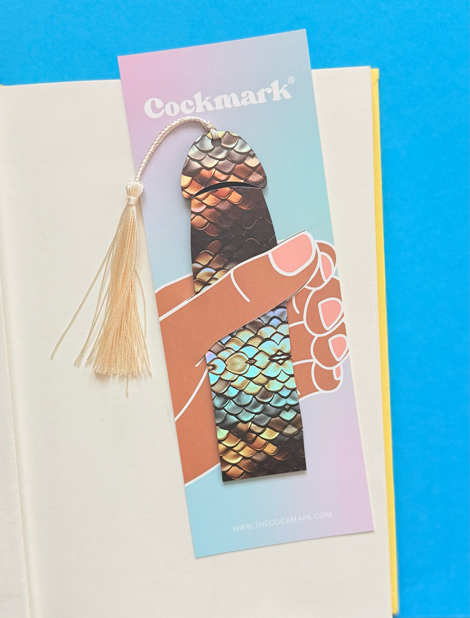 Decorative bookmark with metallic design on a colorful card against a blue background
