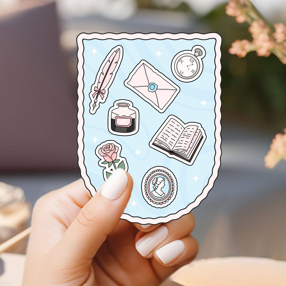 Hand holding a sheet of decorative stickers with literary-themed designs.