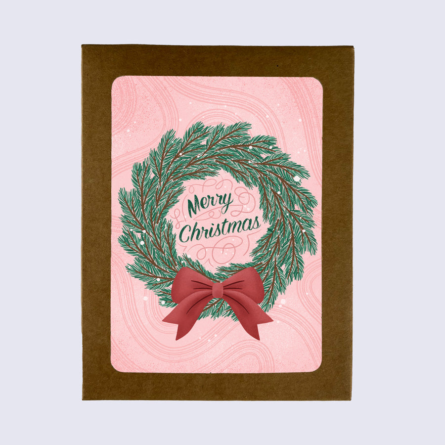 A folded greeting card with a Christmas wreath design and &