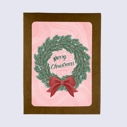 A folded greeting card with a Christmas wreath design and &