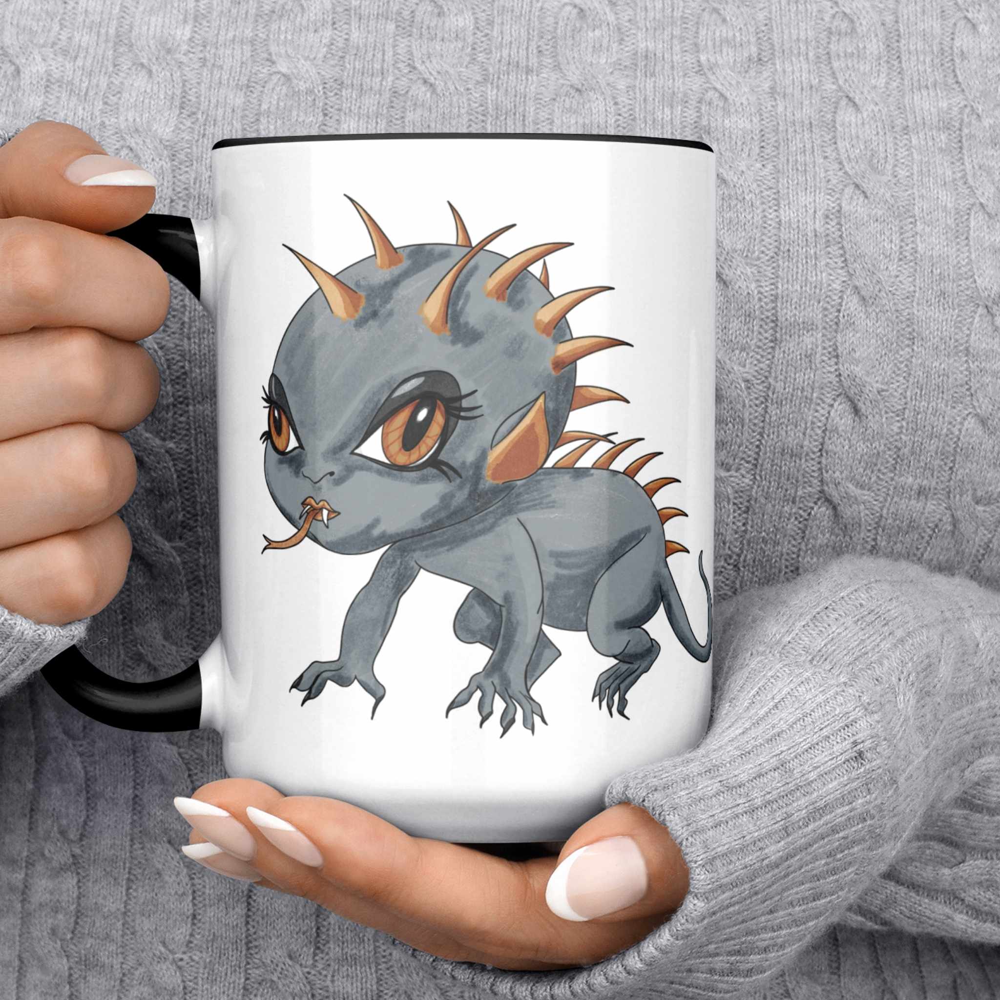 Person in a gray sweater holding the cute Chupacabra cryptid mug
