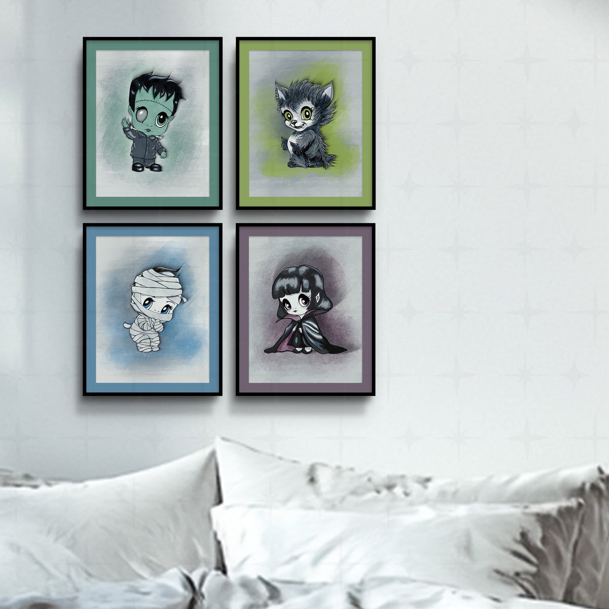Classic monster art print set in black frames with sage, olive, blue, and plum mats, hung in a grid on a white bedroom wall above crisp white bedding.