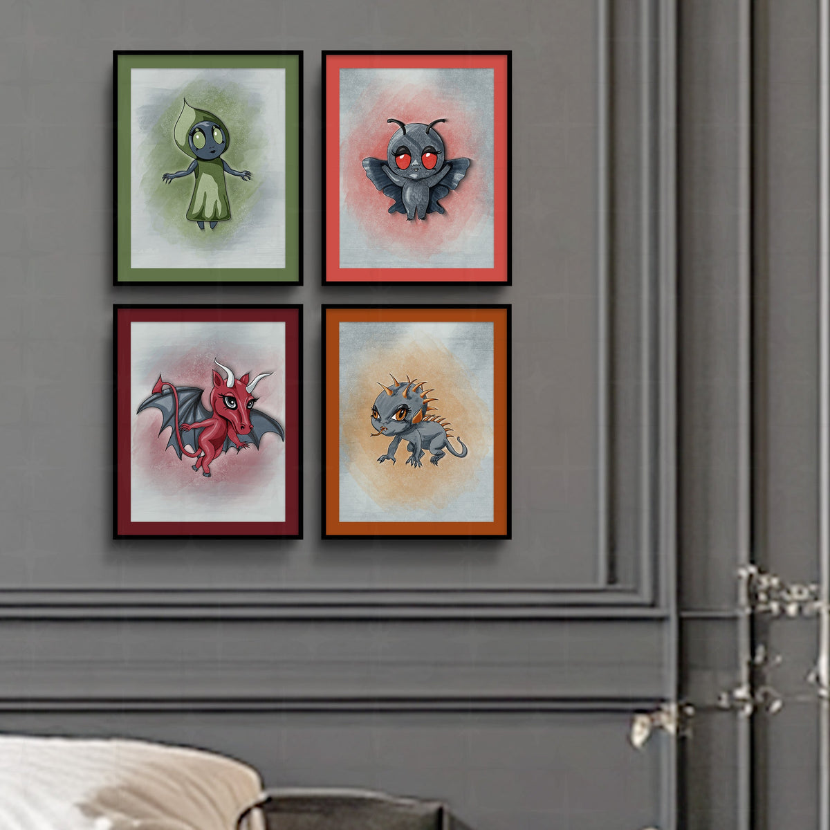 Cryptid gallery wall set of 4 hung in a 2x2 grid with colored mats on a gray paneled wall above a bed, featuring the Flatwoods Monster in green and Mothman in coral.