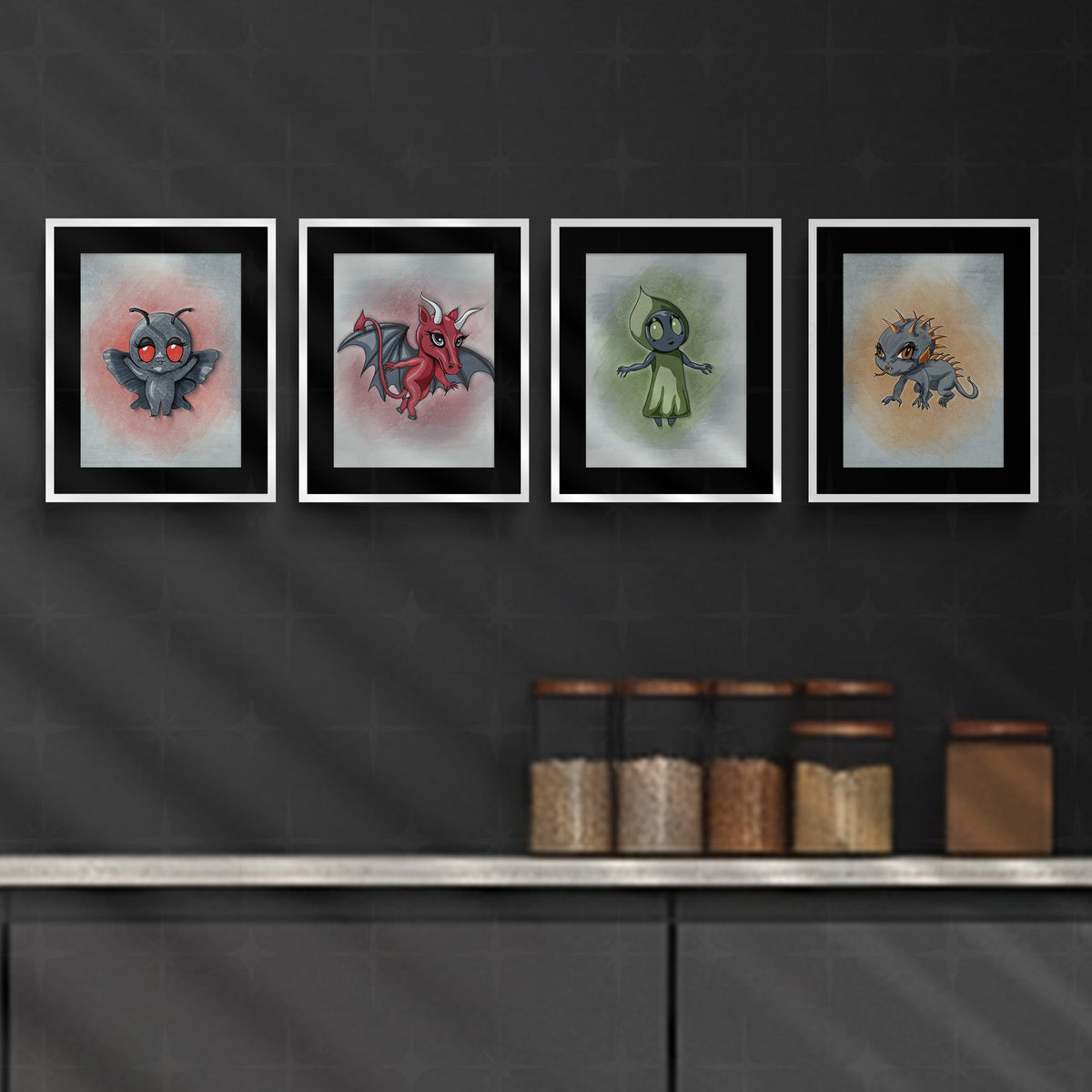 Four cryptid wall art prints in white frames displayed in a row above a dark kitchen counter with glass storage jars.