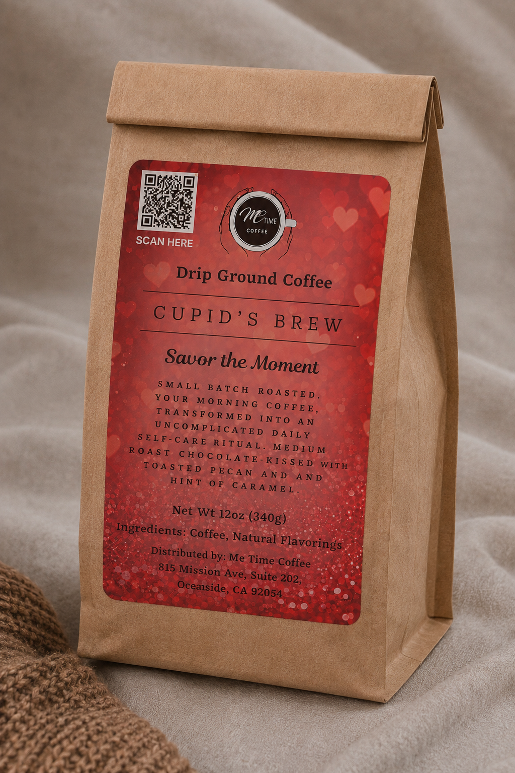 A kraft paper coffee bag standing upright on a neutral fabric surface. The bag has a large red label reading &