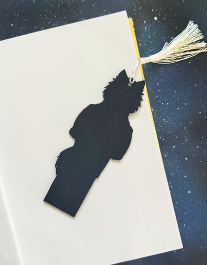 Black silhouette of a person on a white card with a tassel against a dark background