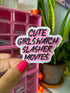 A hand with bright pink nail polish holds a die-cut sticker that reads &