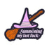 A die-cut sticker featuring a cartoon witch hat and broomstick with the text &