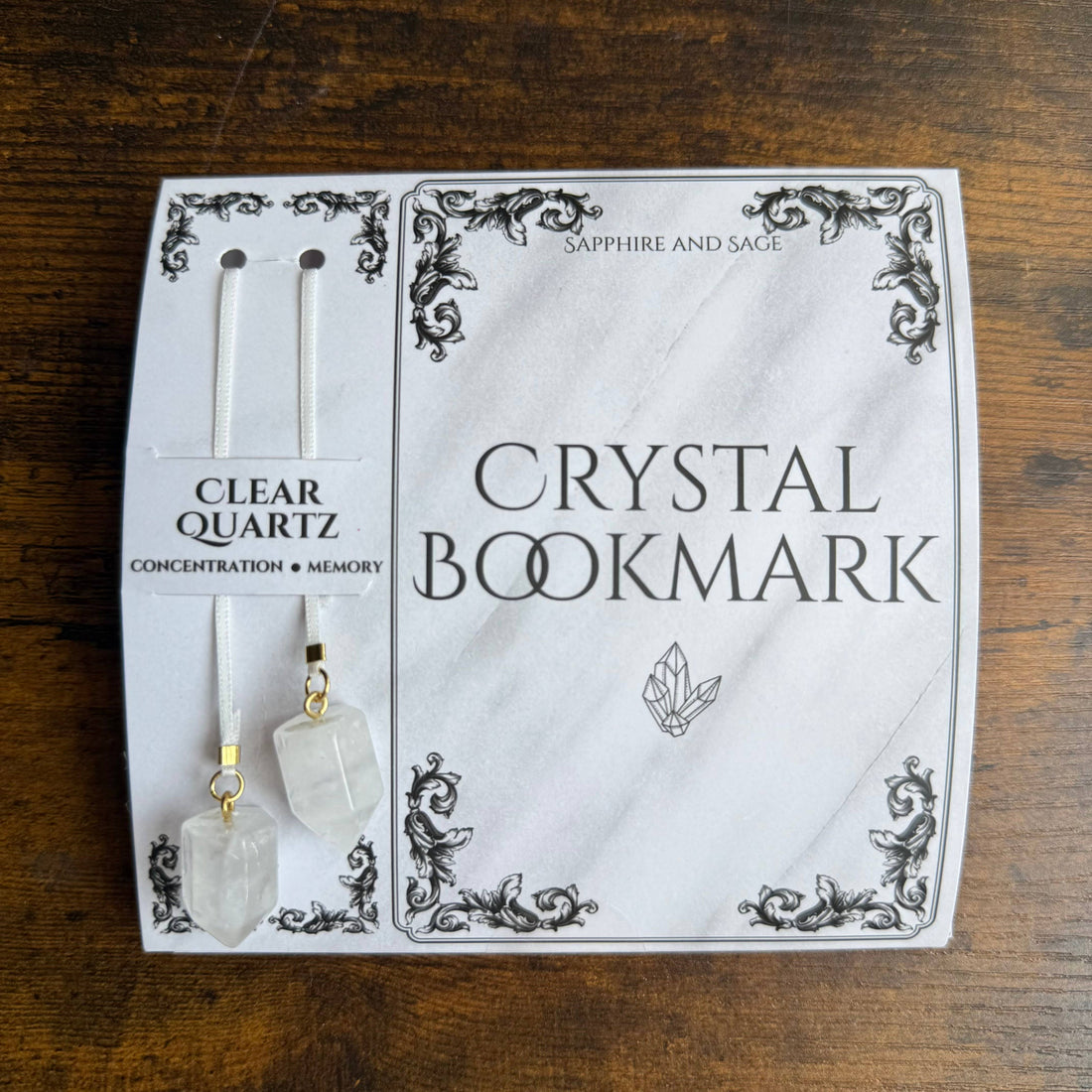 Crystal bookmark packaging with clear quartz stones on a wooden surface