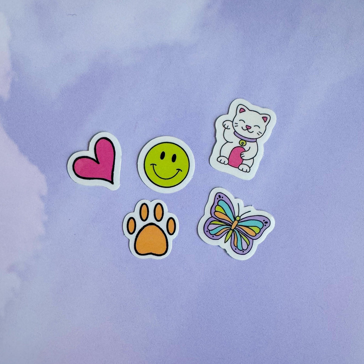 Doodles mini sticker set - lucky cat, smile, butterfly, paw, heart flat lay — clear vinyl mini filler stickers by indie artist MangoIllustrated