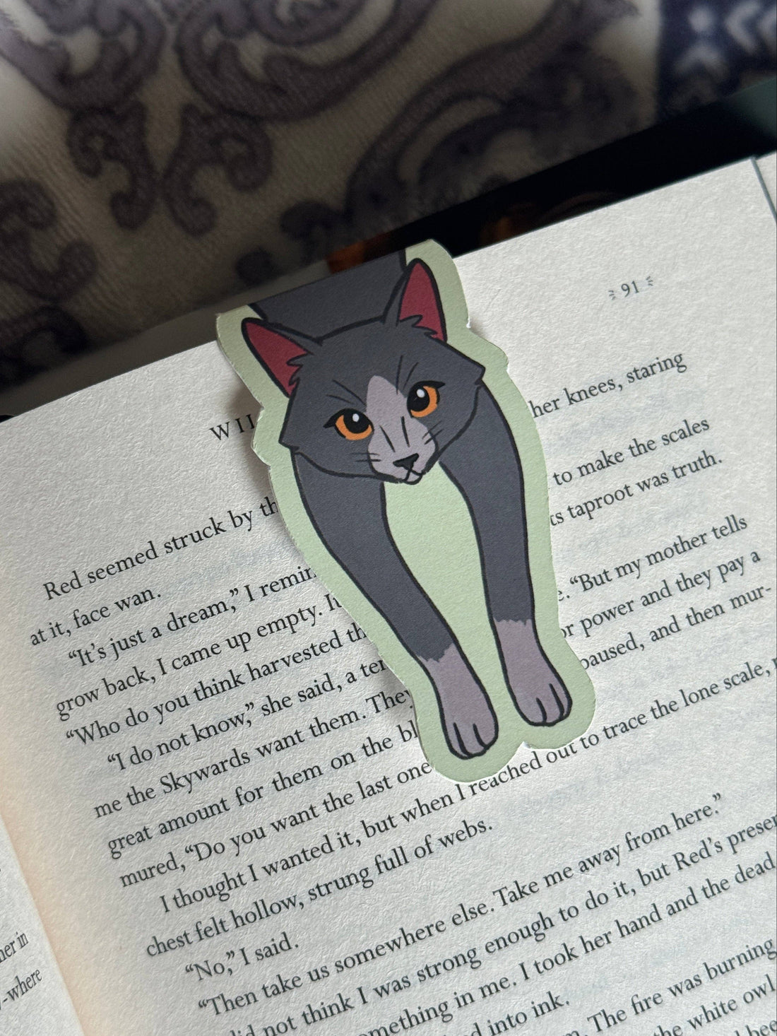 Cat-shaped bookmark on an open book