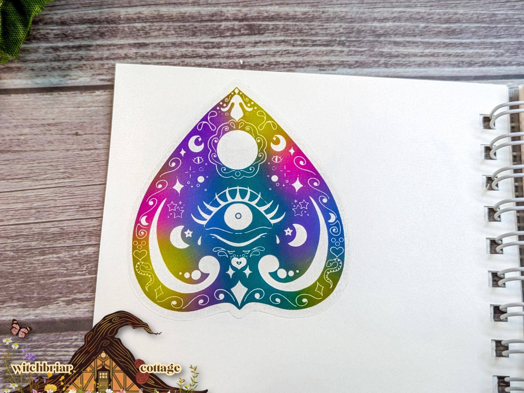 Colorful teardrop-shaped design with a symbol on a notebook
