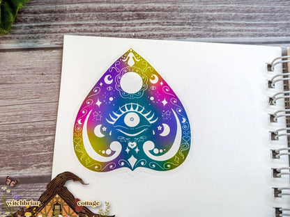 Colorful teardrop-shaped design with a symbol on a notebook