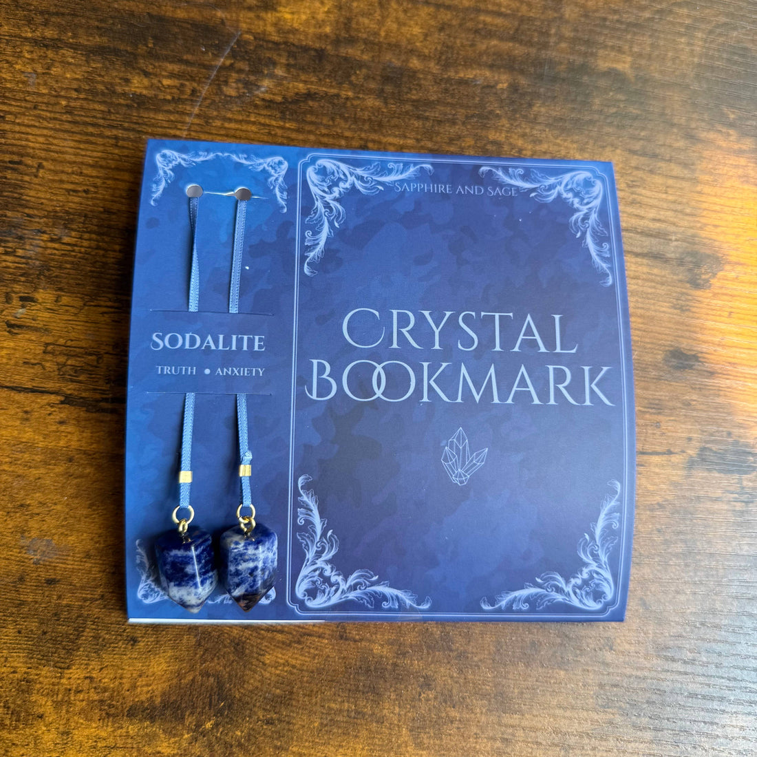 Crystal bookmark and earrings set on a wooden surface